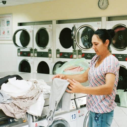 How to Get Musty Smell Out of Clothes - Woman folding clothes inside the laundry shop