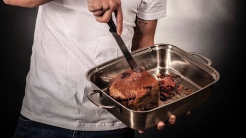 How to Clean Baking Pans and Aluminum Baking Sheets 9 guy cutting a fruitcake inside a pan with a knife